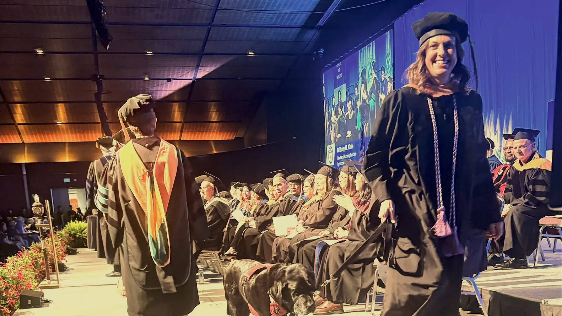 Woman and dog walk across stage