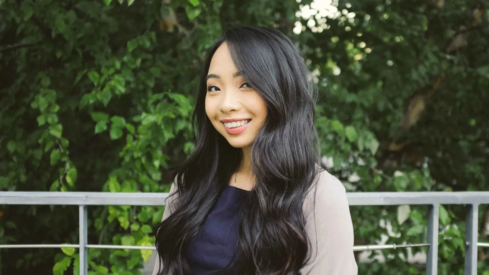 Woman smiles standing outside