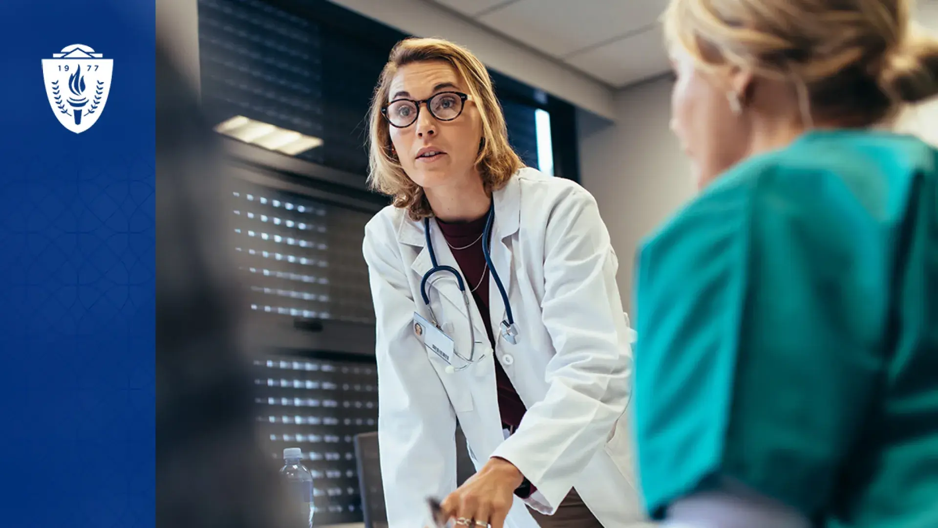 woman in white lab coat and stethoscope leads group of people - nearest one is in scrubs