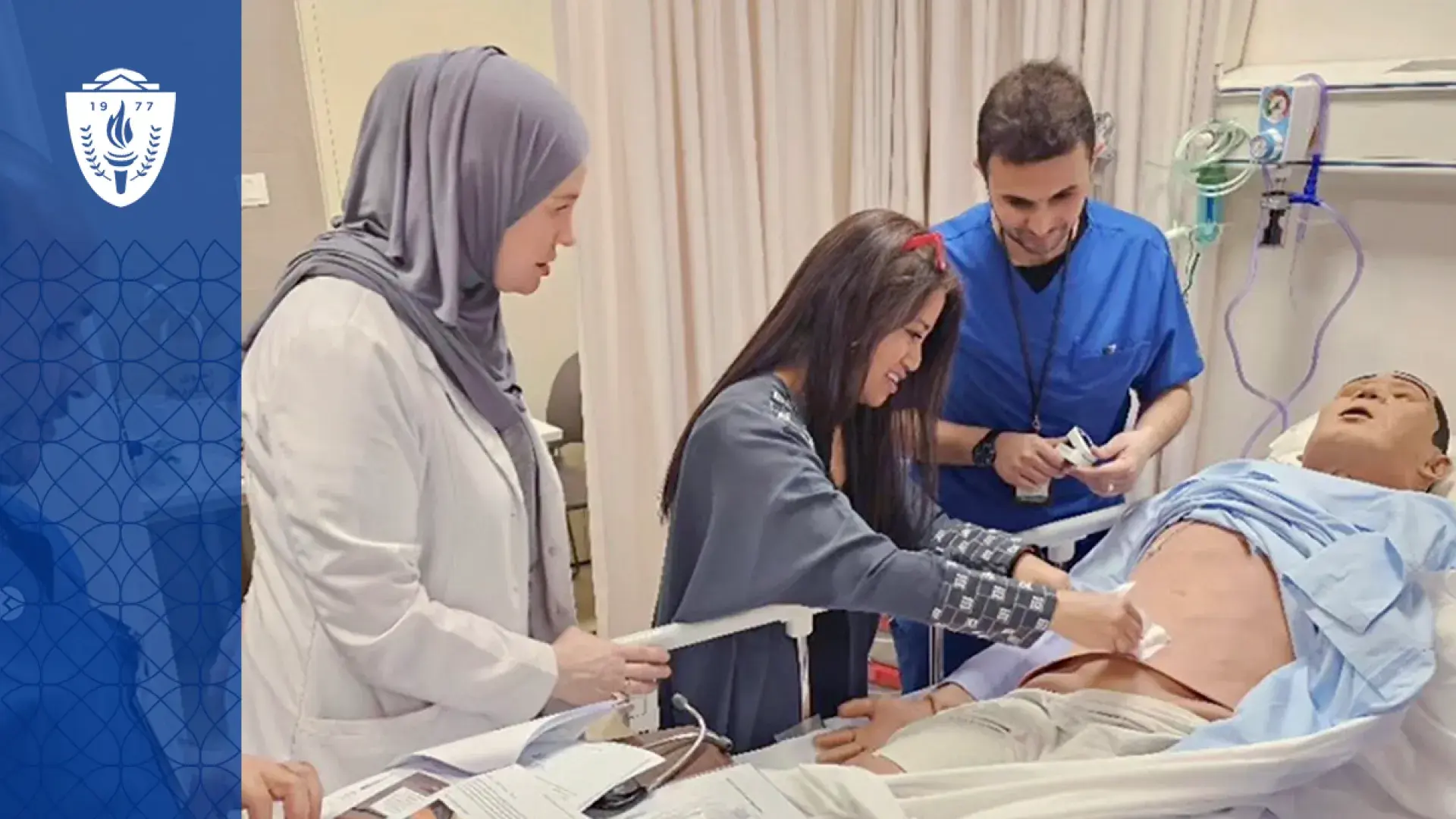 a woman shows two students something on a manikin's stomach at a hospital bedside