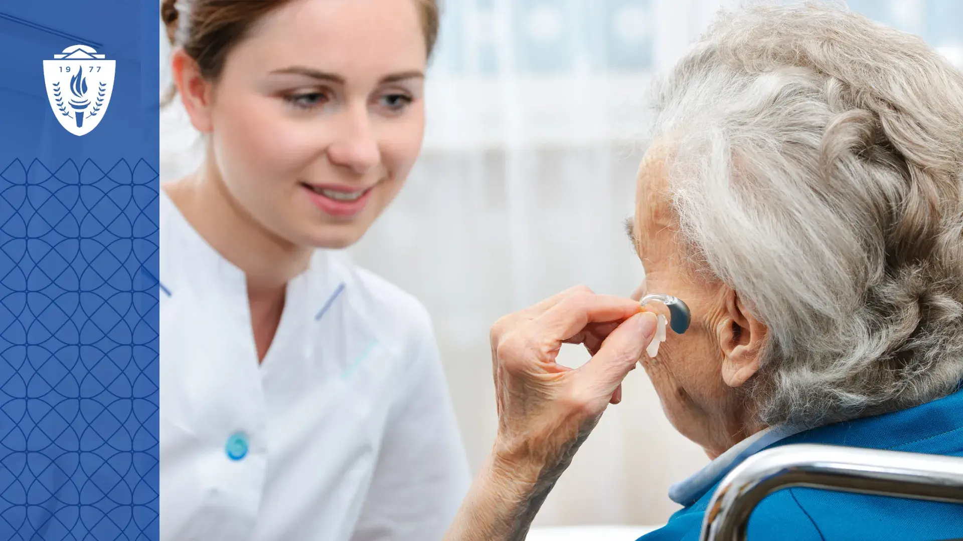 woman with grey hair holds a hearing aid up to her ear while a woman in a lab coat looks on