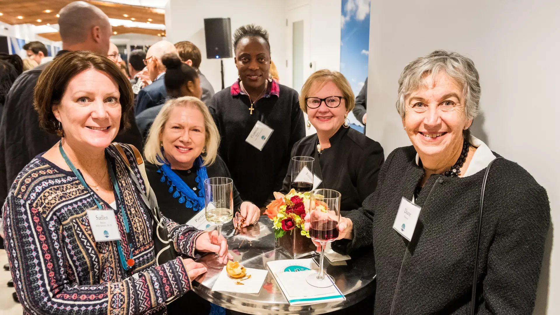 Five people standing around a high table at a celebration