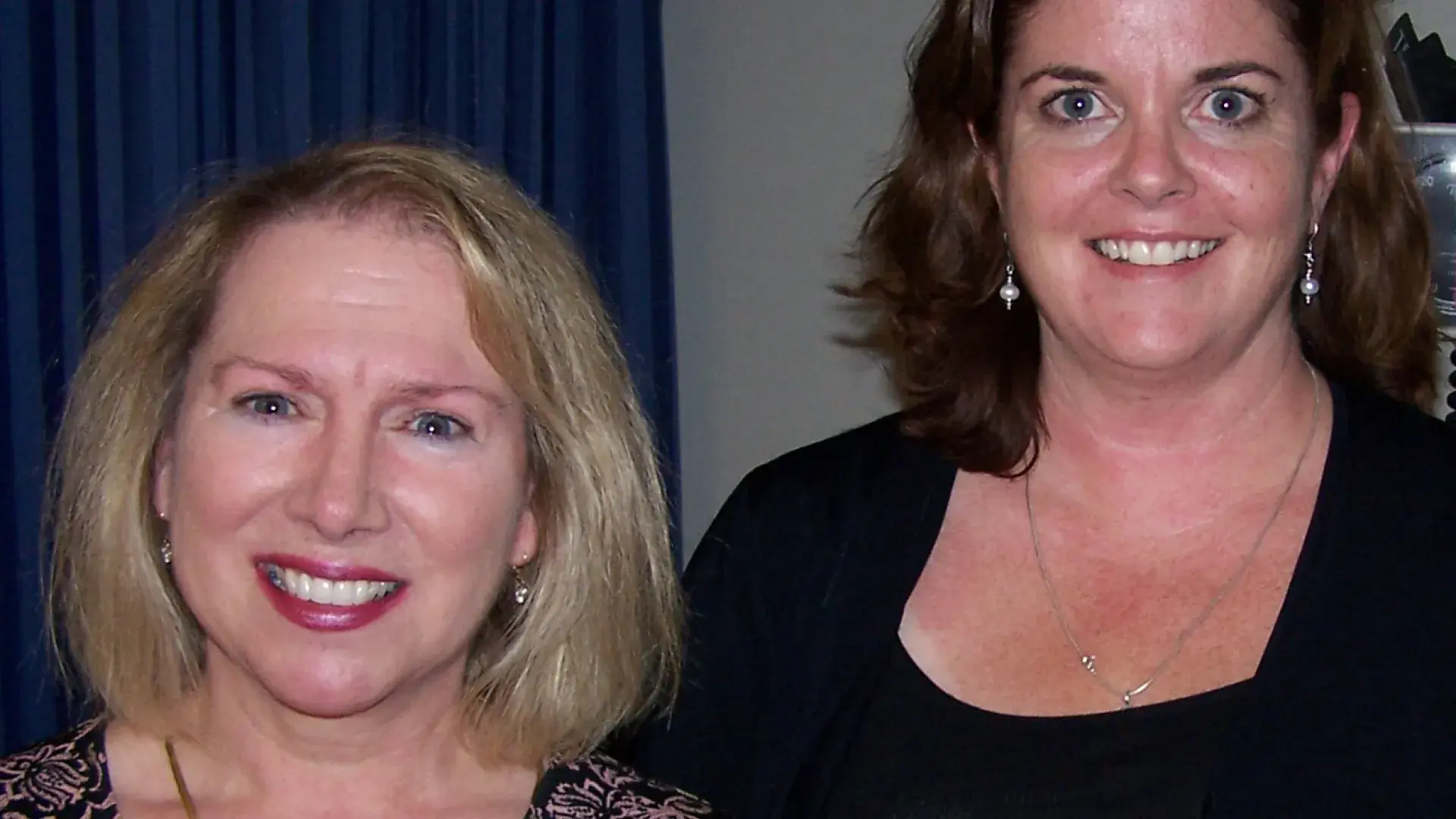 Two women standing next to each other posing for a photo