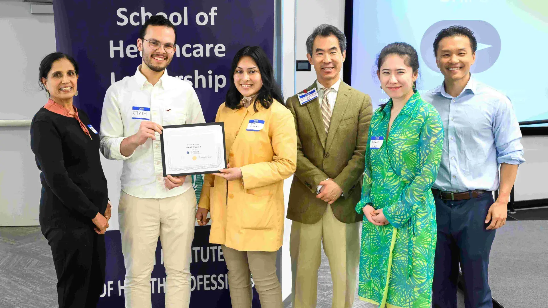 Six people smiling holding an award