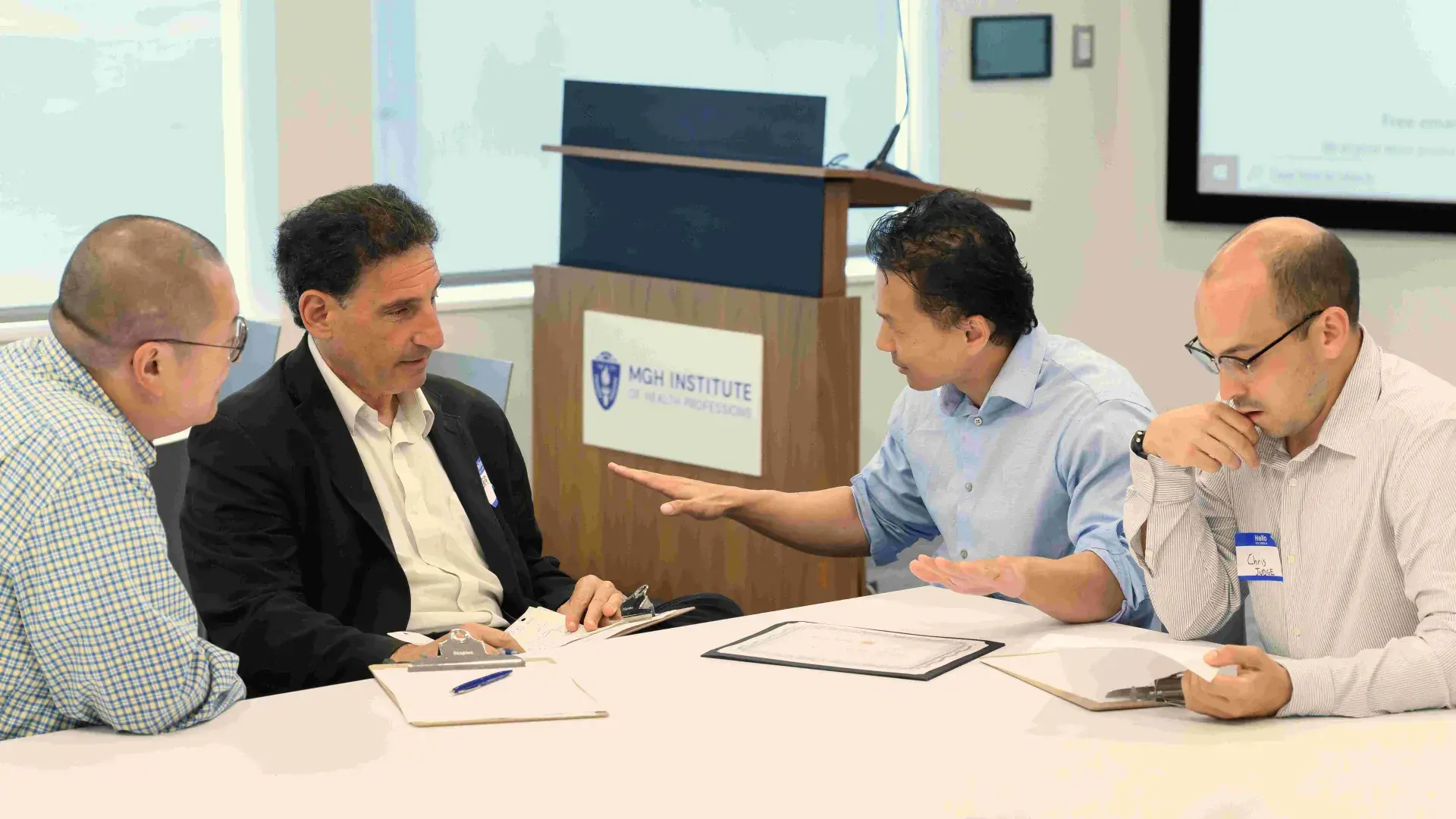 Four men talking around a table