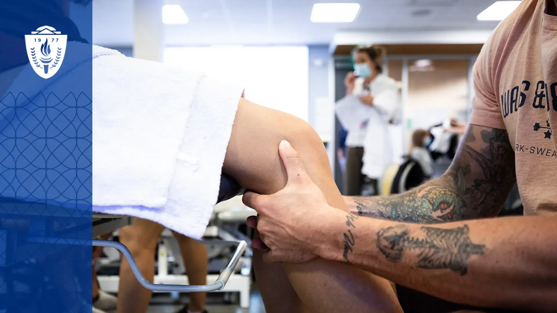 a person sits in front of another who is on a medical table, the focus are the person's hands around the other's knee