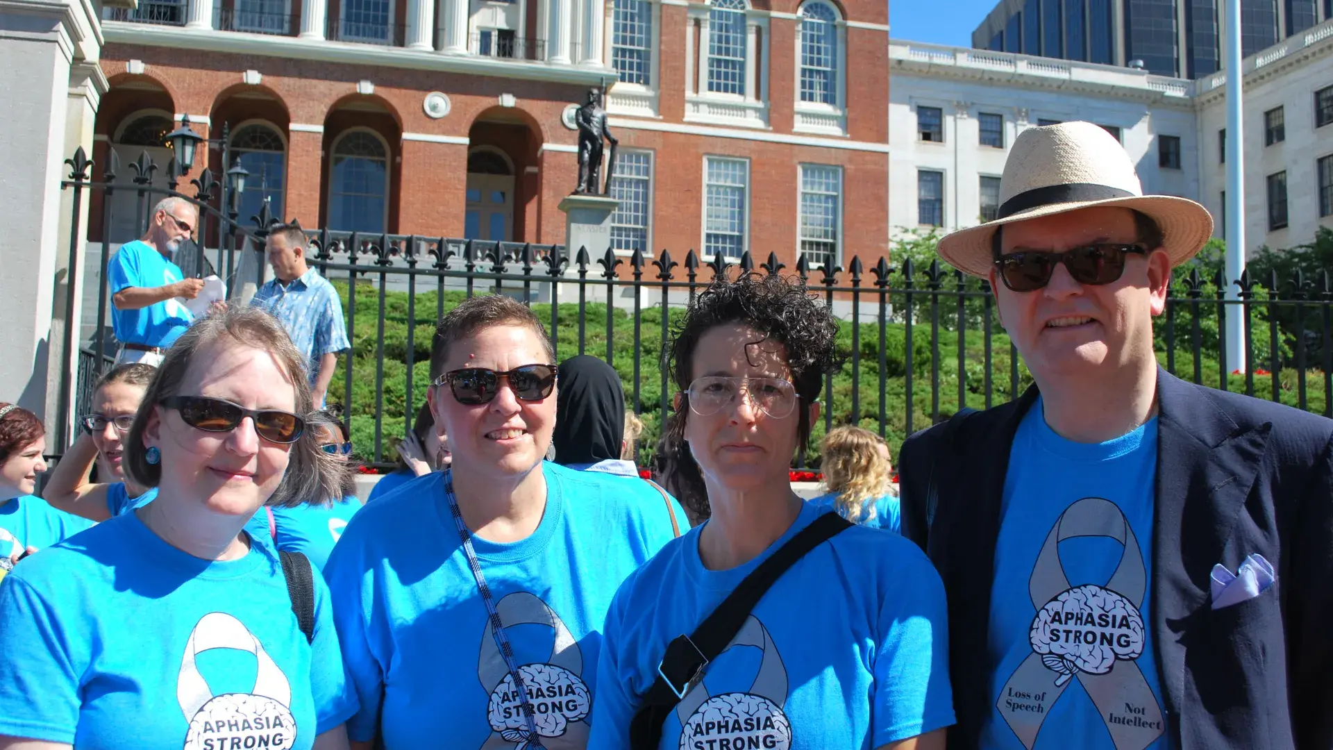 Four people pose in front of a government building