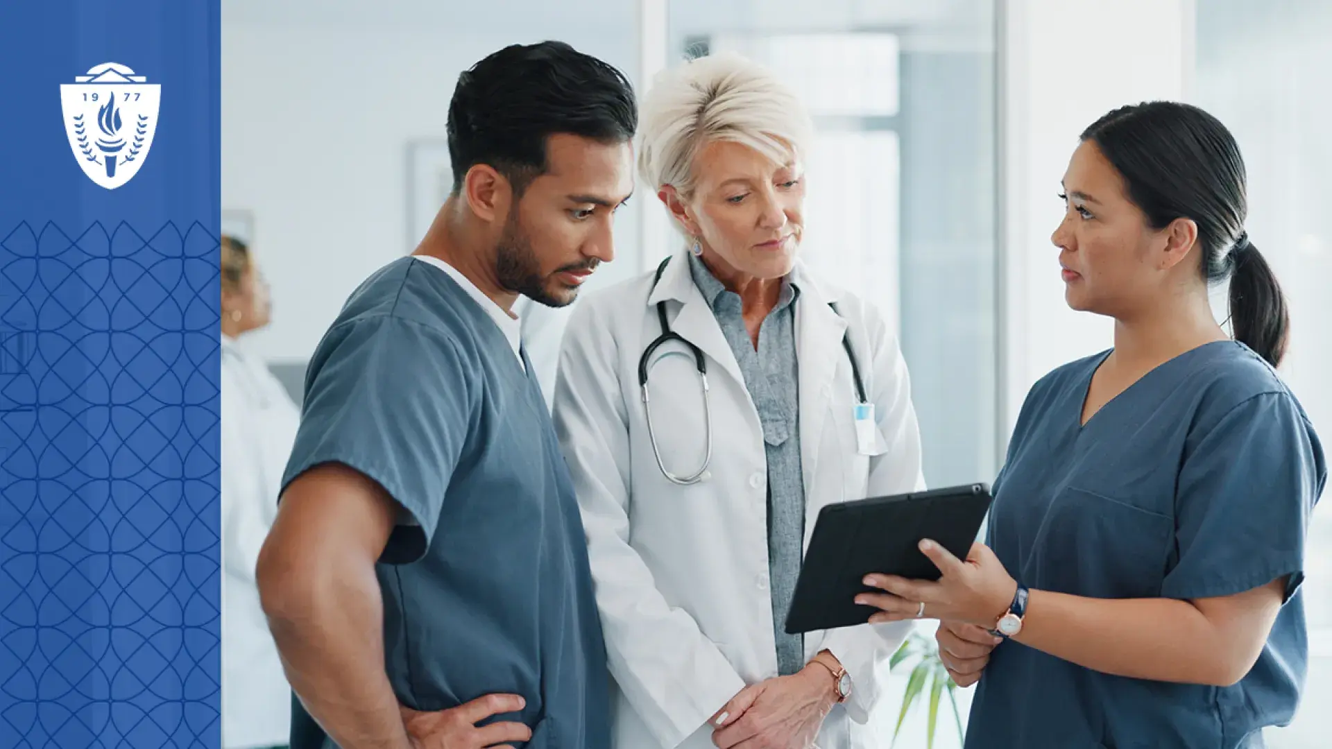 a woman in scrubs shows a tablet to a man in scrubs and an older woman in a lab coat
