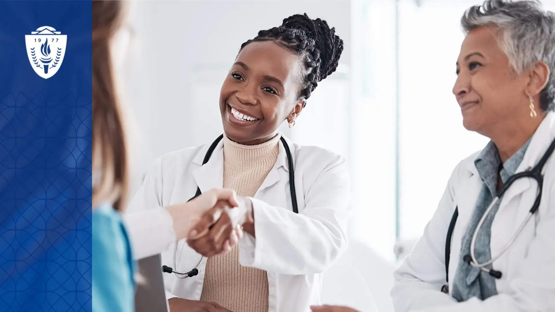 woman in white coat and stethoscope shakes the hand of another person off camera