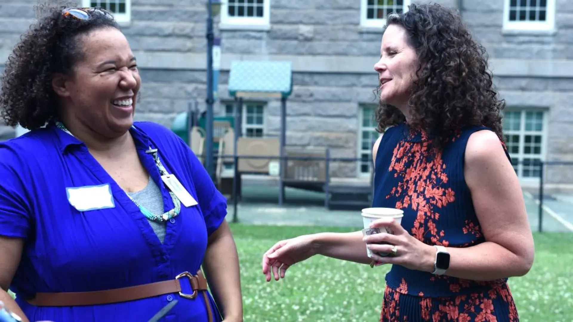 Two women laugh while talking