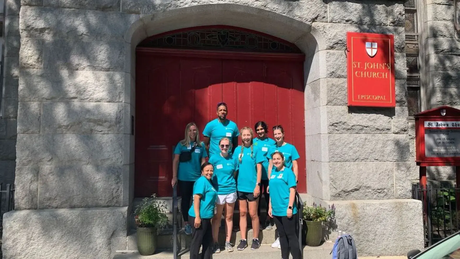 People pose in front of a church