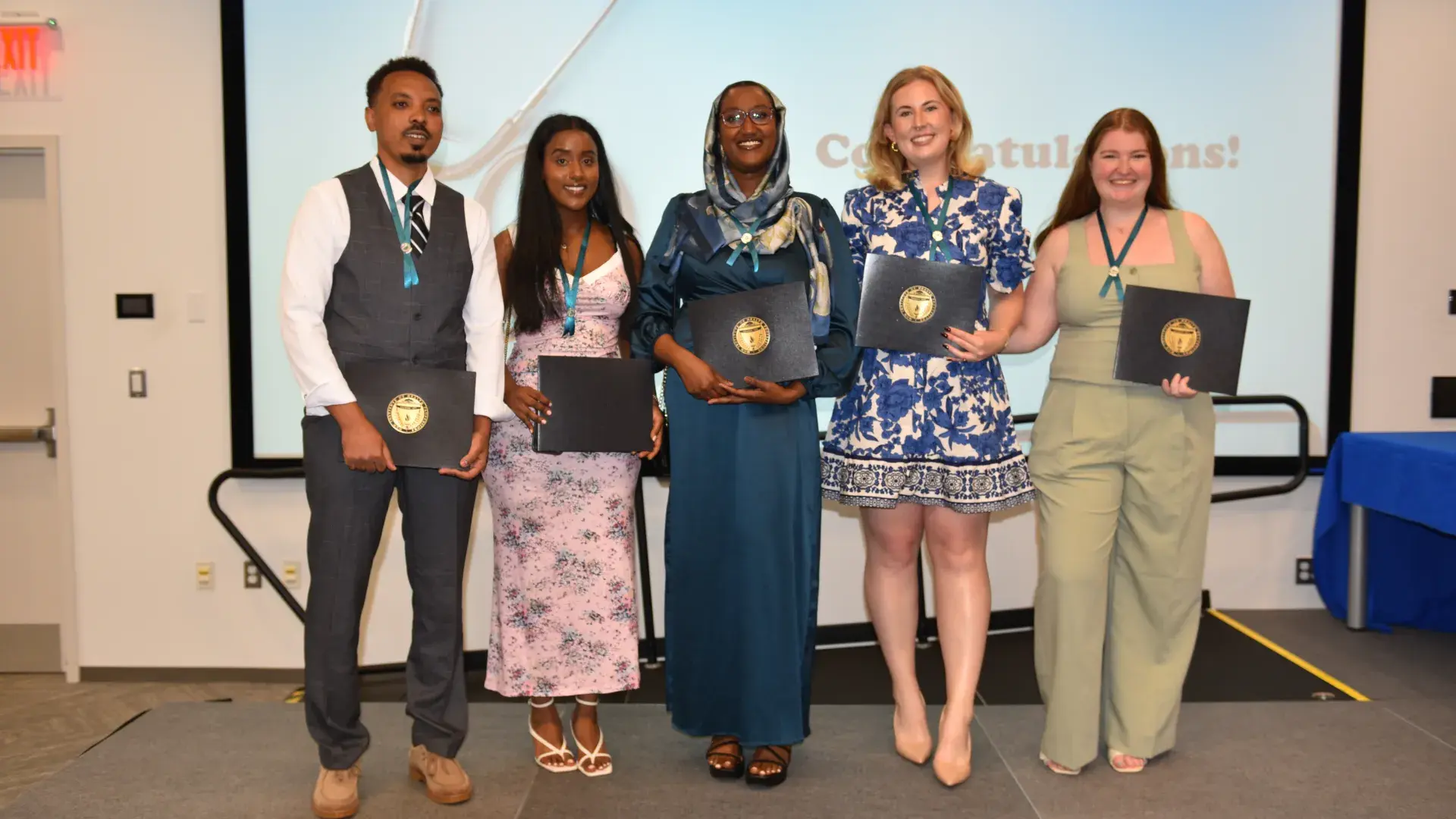 Five people pose with awards