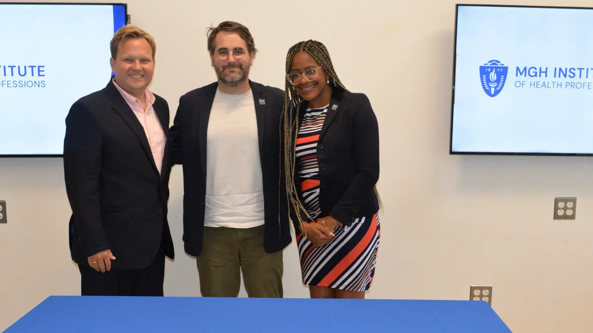 3 people standing in front of a table. 