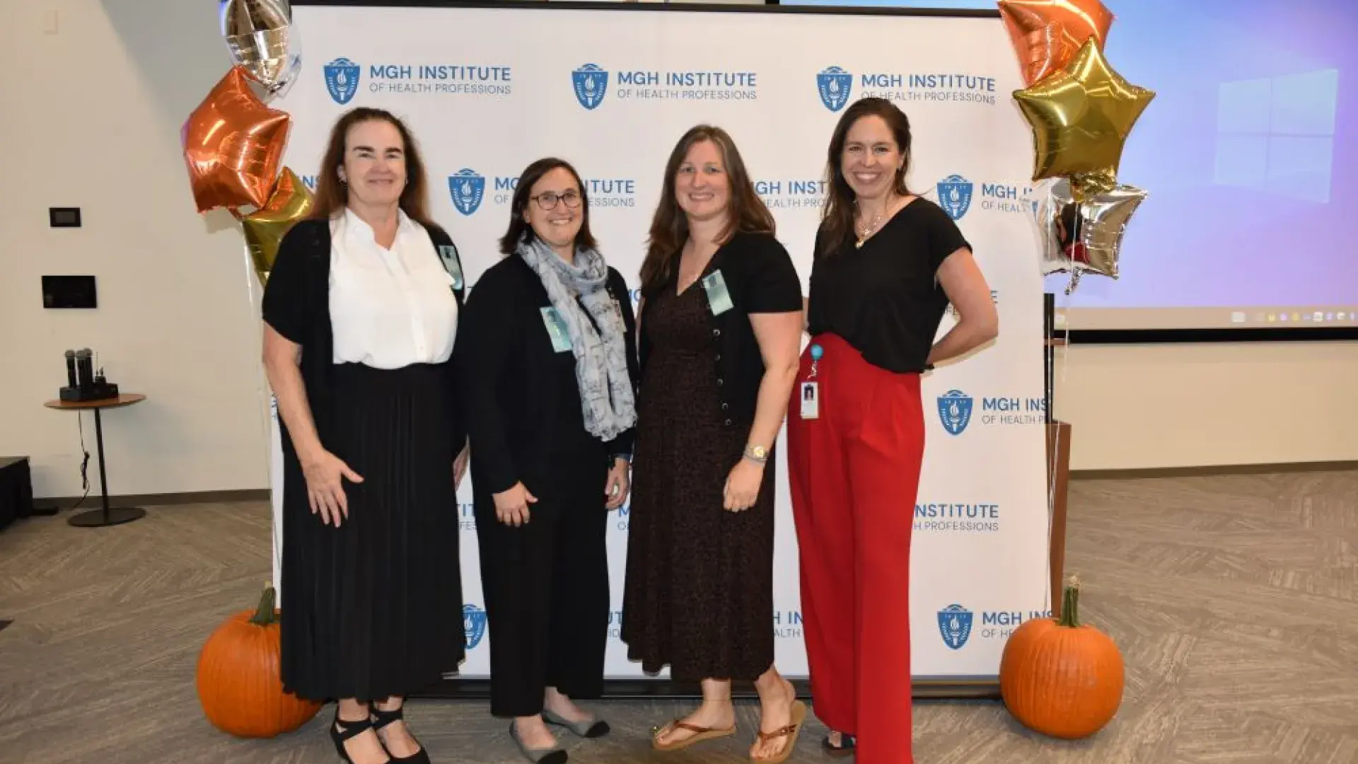group stands in front of MGH banner