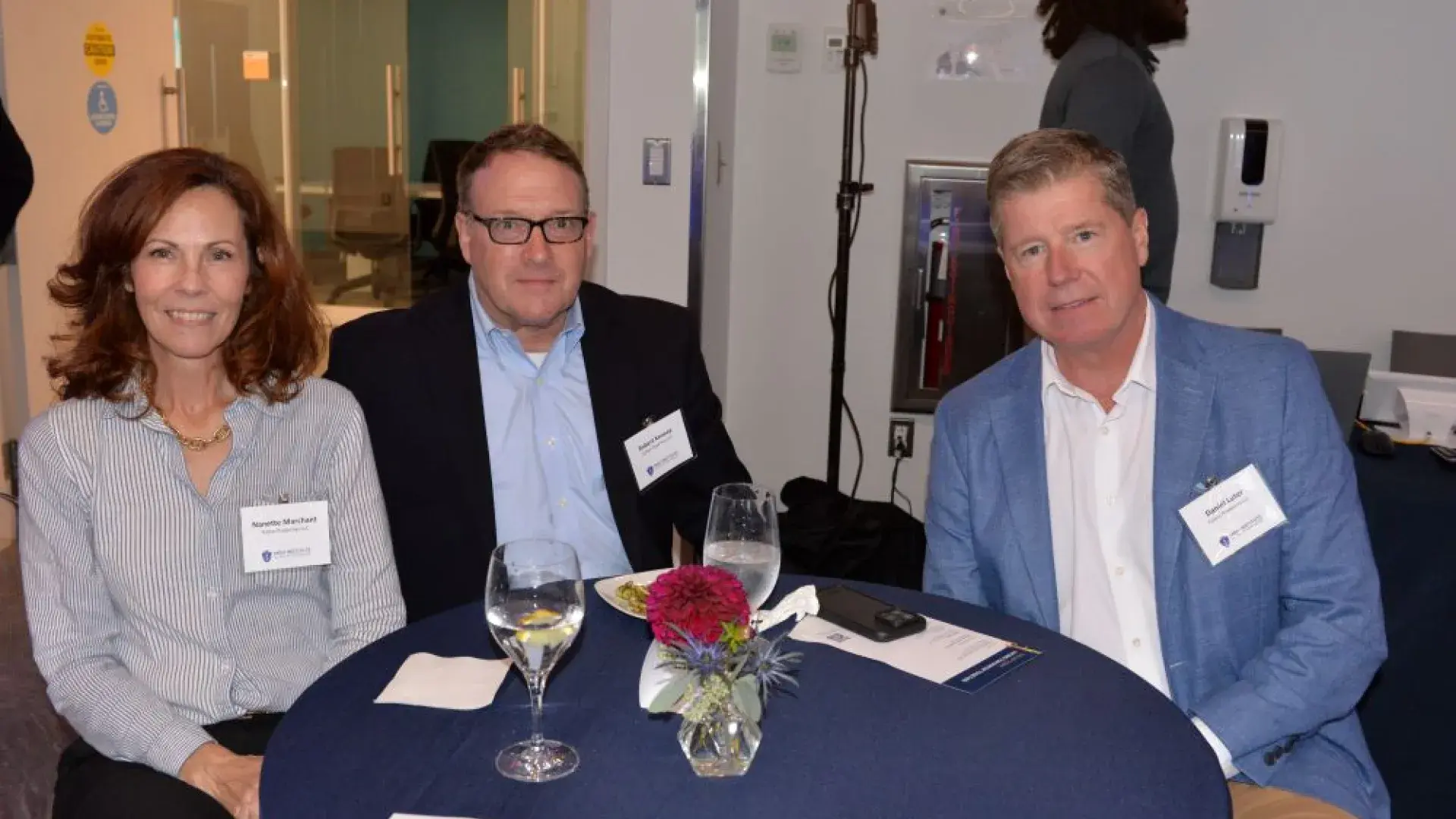Three attendees seated at a table during the MGH Institute of Health Professions healthcare networking event.