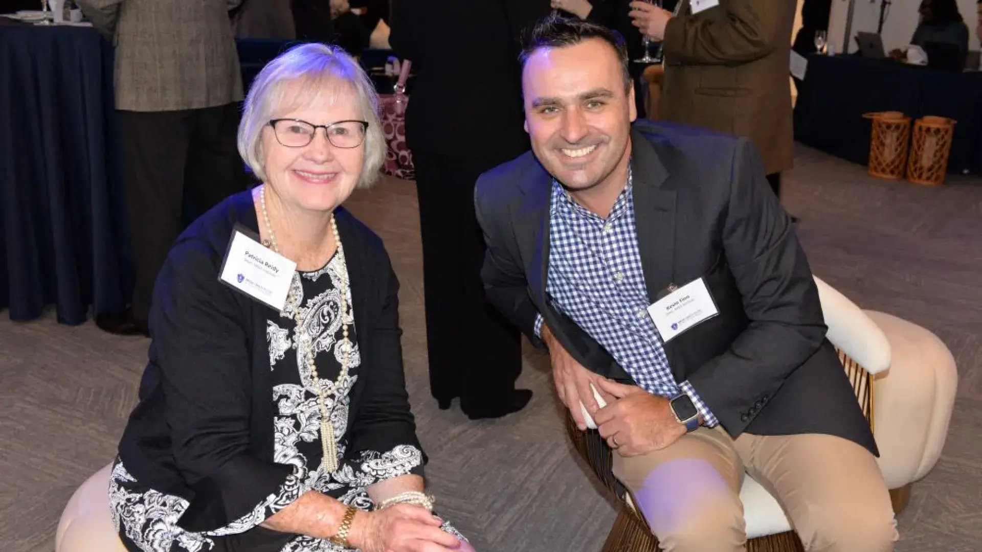 Two attendees smiling and connecting during the MGH Institute of Health Professions networking event.