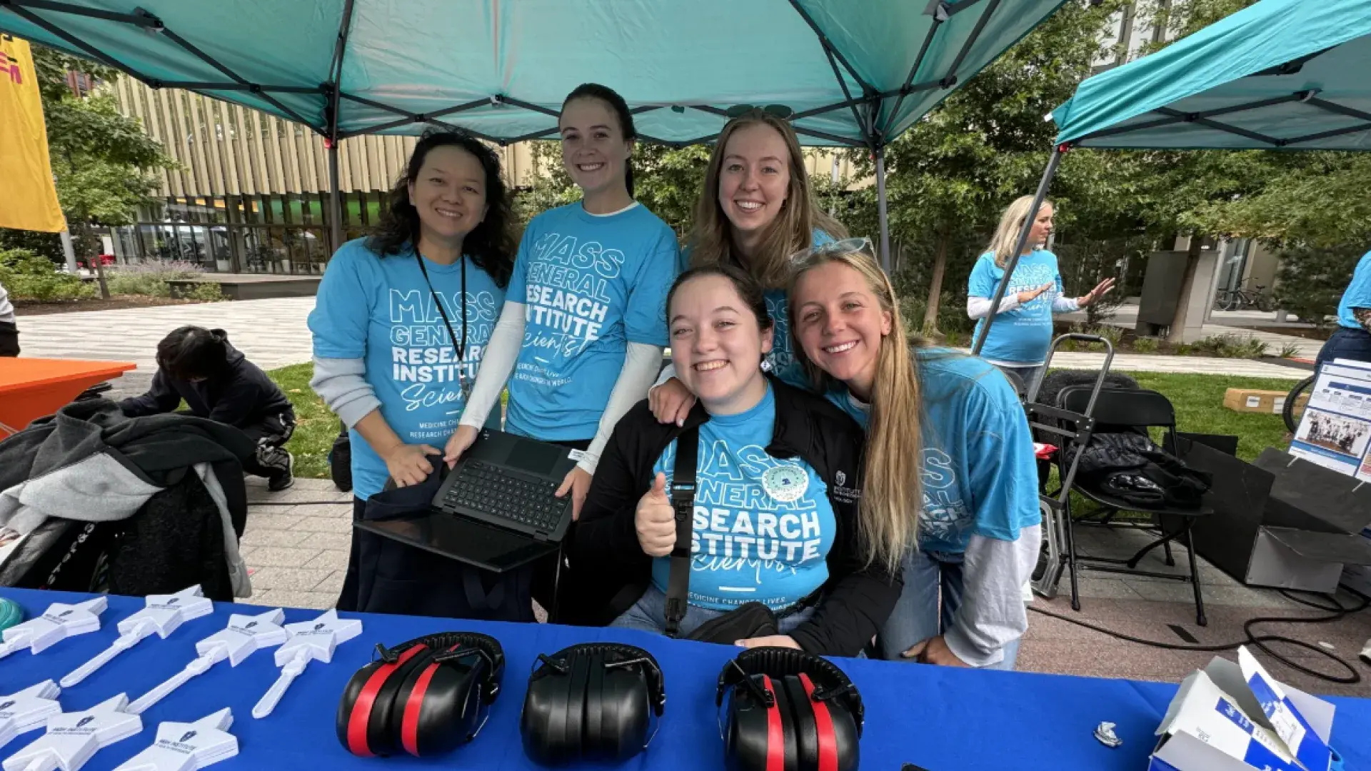 5 women at a booth with headphones on the table