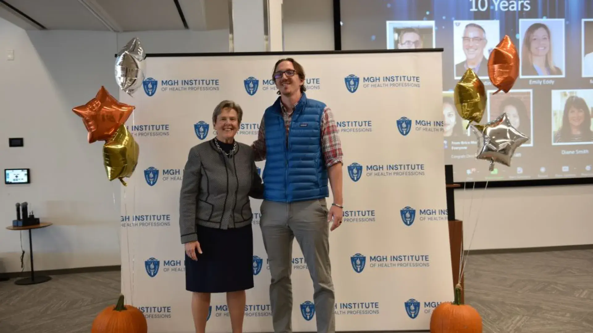 man and woman stand in front of MGH banner