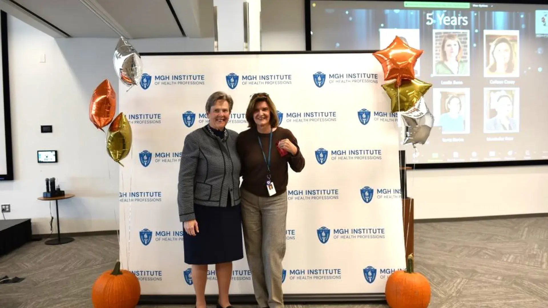 two women stand in front of MGH banner
