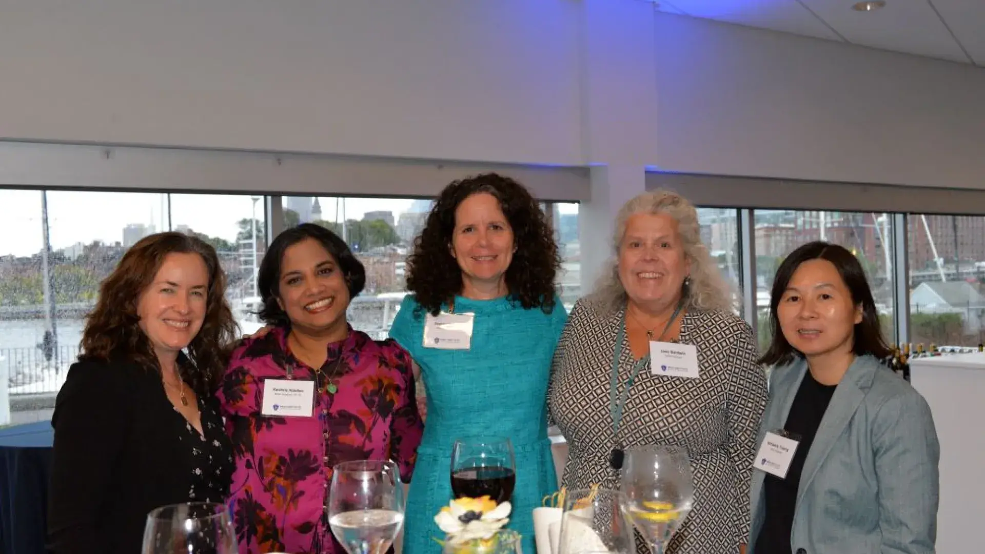 A group of attendees smiling and networking during the MGH Institute of Health Professions healthcare event