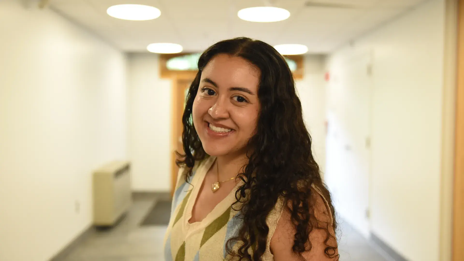A woman stands in a hallway