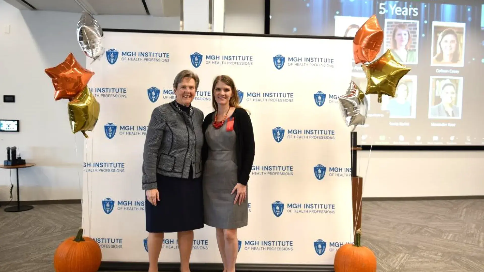 man and woman stand in front of MGH banner with award