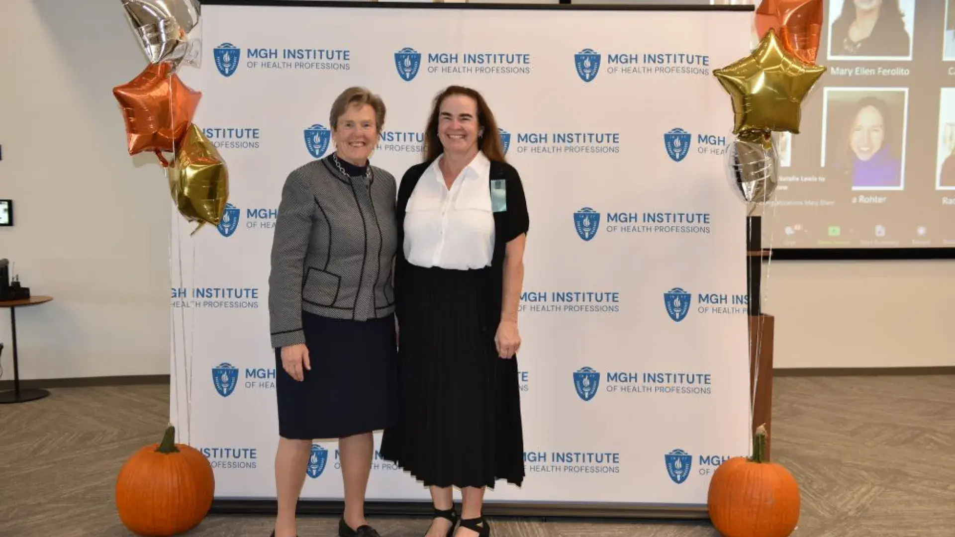 two women stand in front of MGH banner