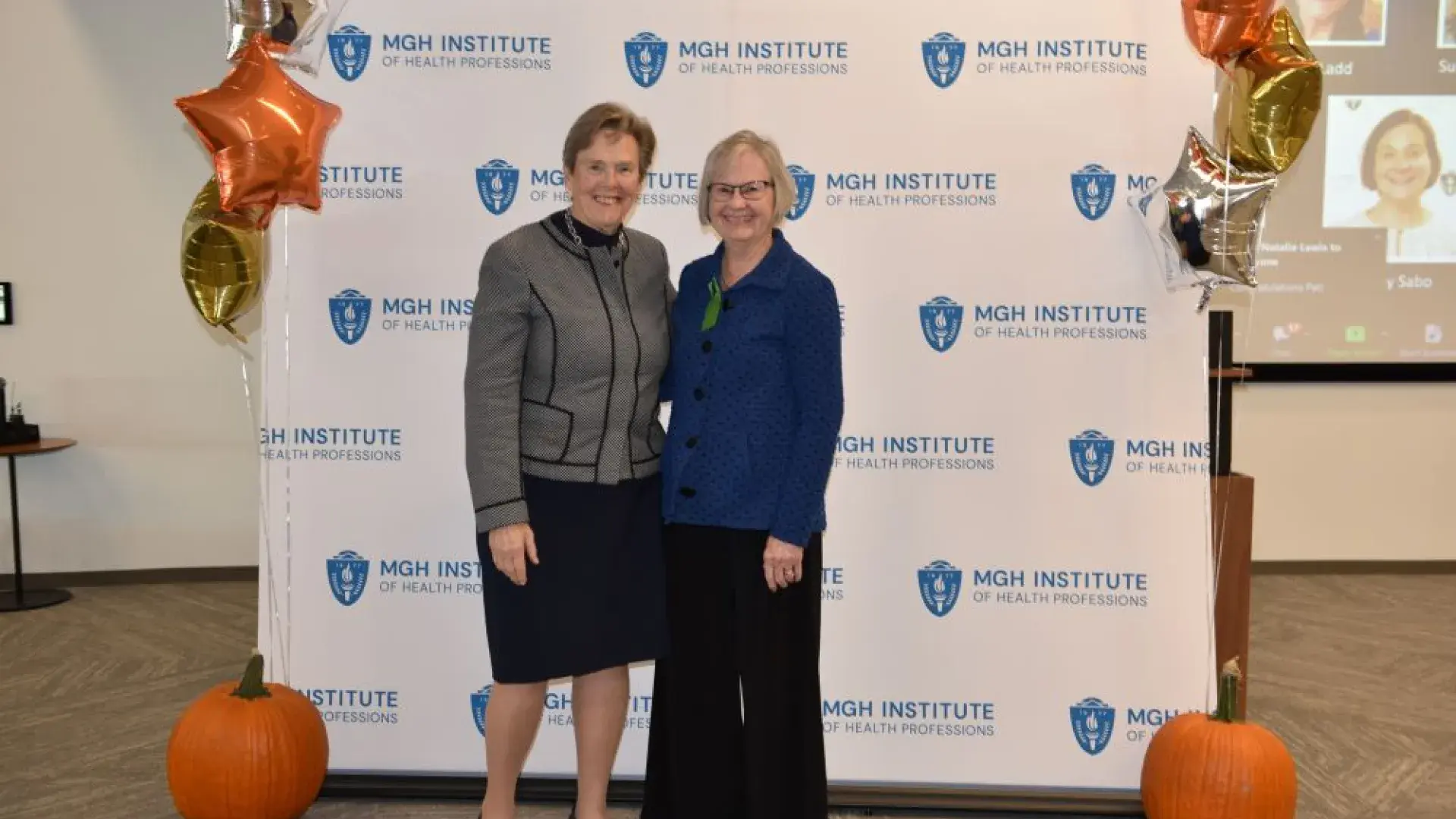 two women stand in front of MGH banner