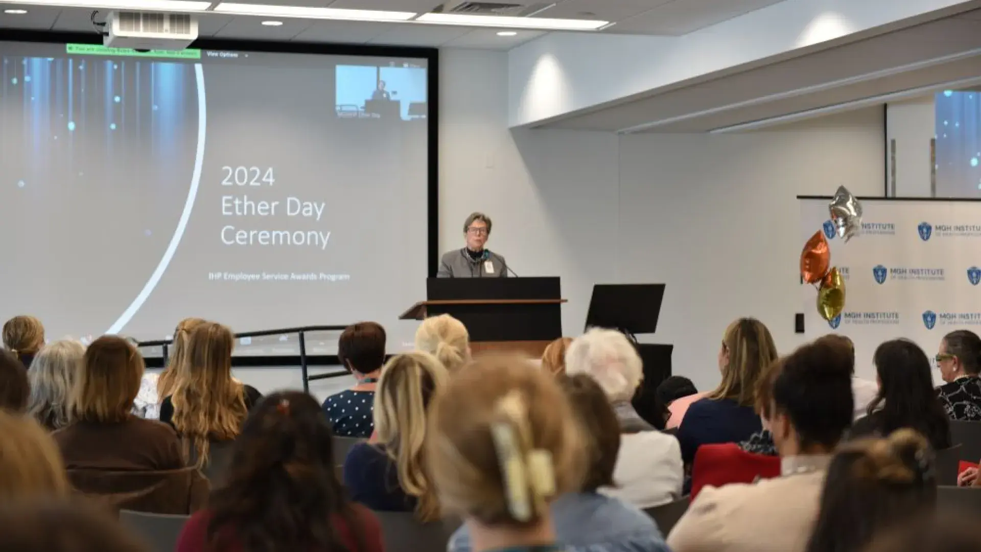 woman stands at podium
