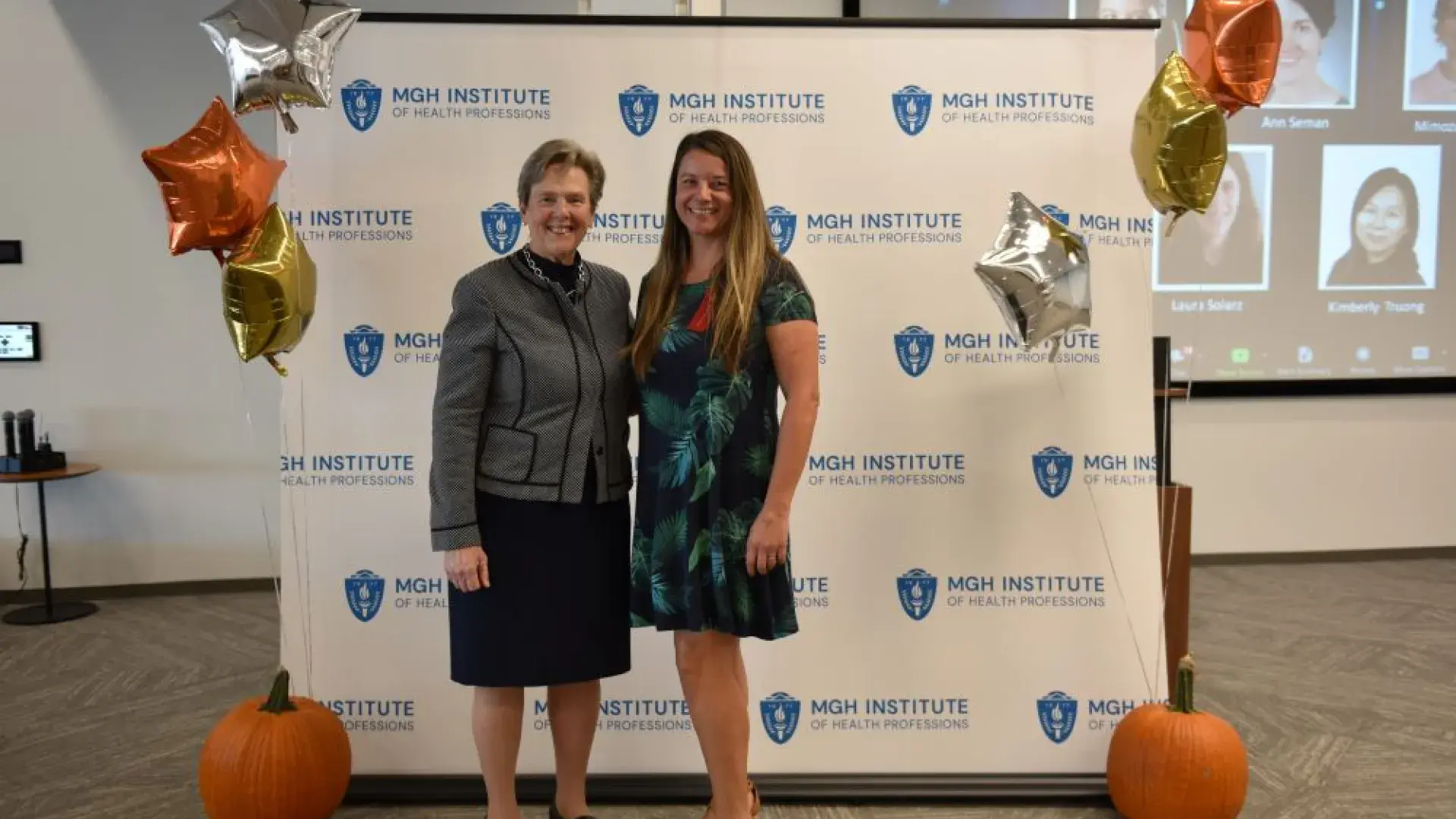 two women stand in front of MGH banner