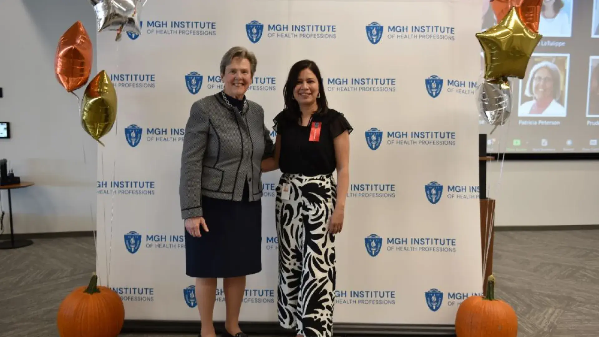 two women stand in front of MGH banner