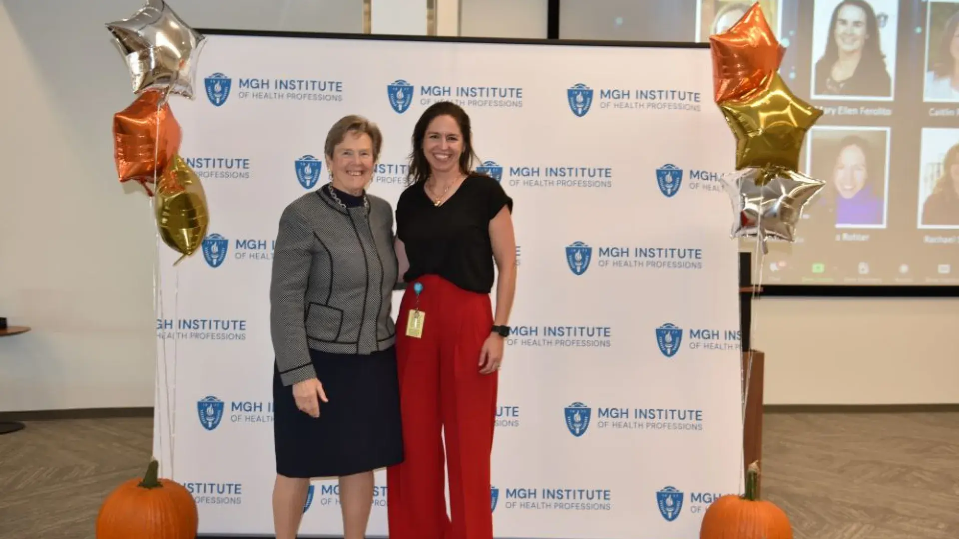 two women stand in front of MGH banner
