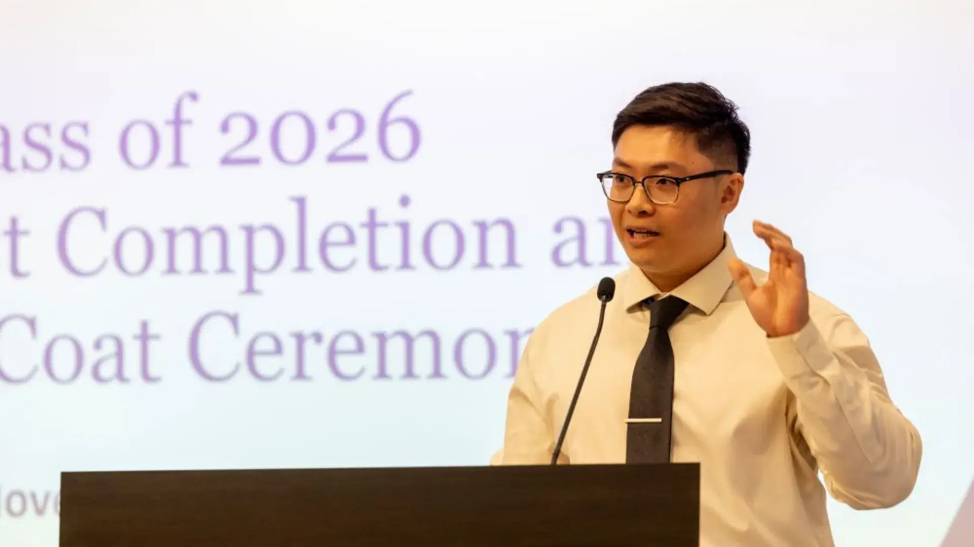 A man stands behind a podium speaking