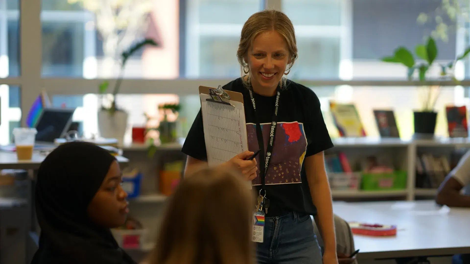 A professional in the MGH IHP Literacy and Language Certificate Program poses confidently in a modern academic setting. The program prepares educators for leadership roles in literacy education, emphasizing teaching reading and writing skills, and literacy leadership training. 