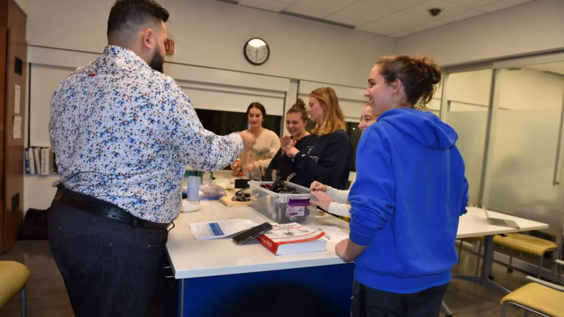 A groupd of people stand around a kitchen island