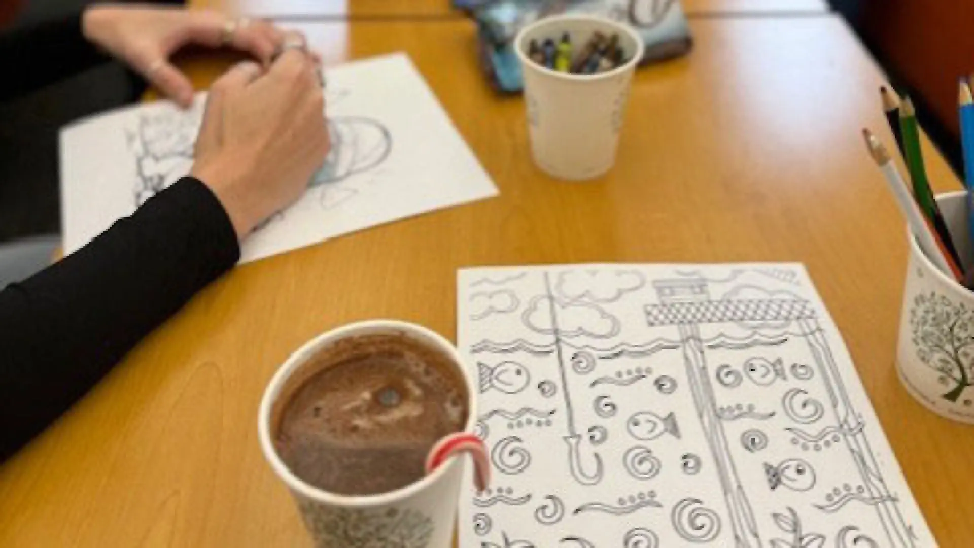 hand with hot cocoa and coloring page