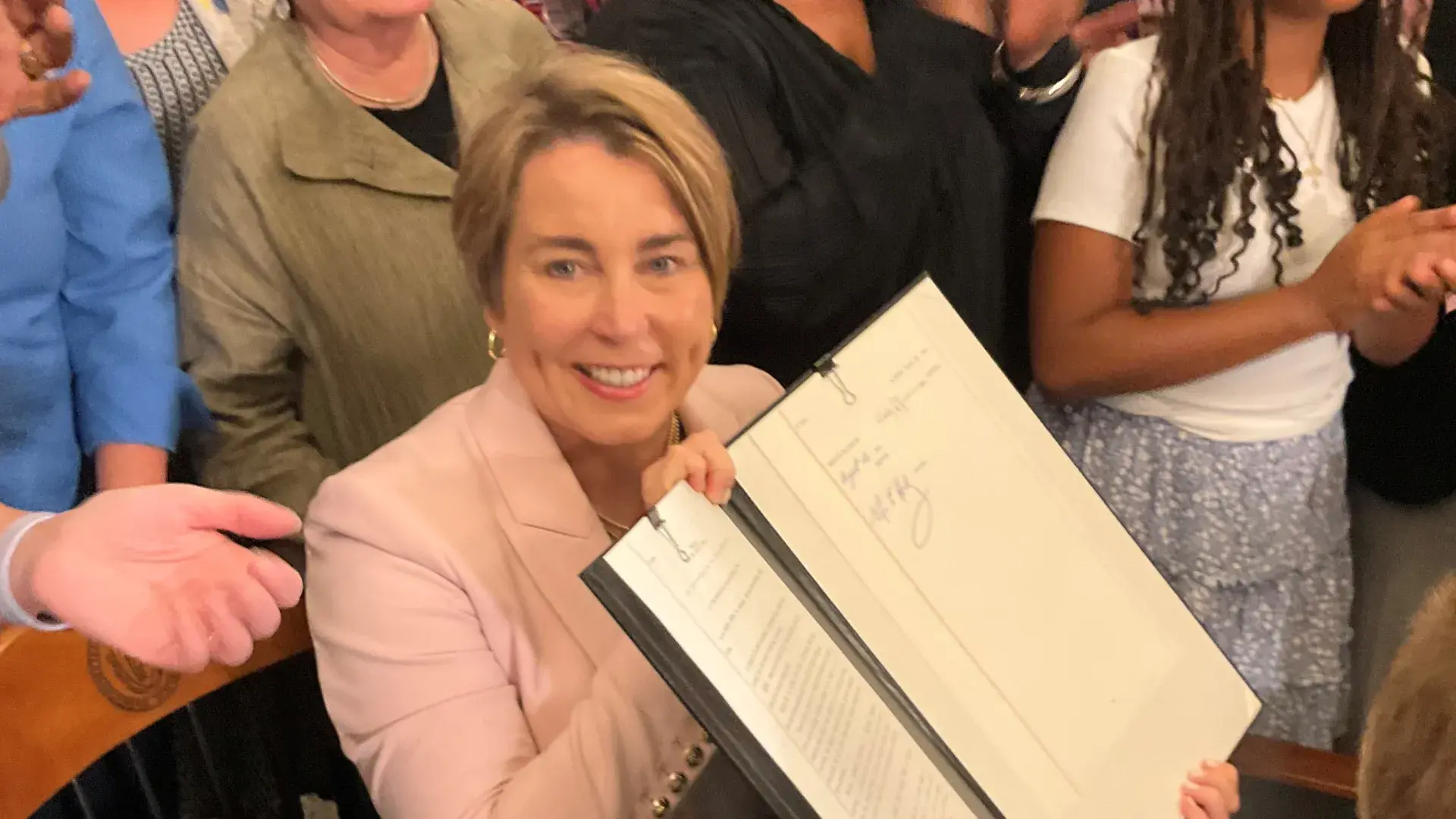 A woman holds up an open folder