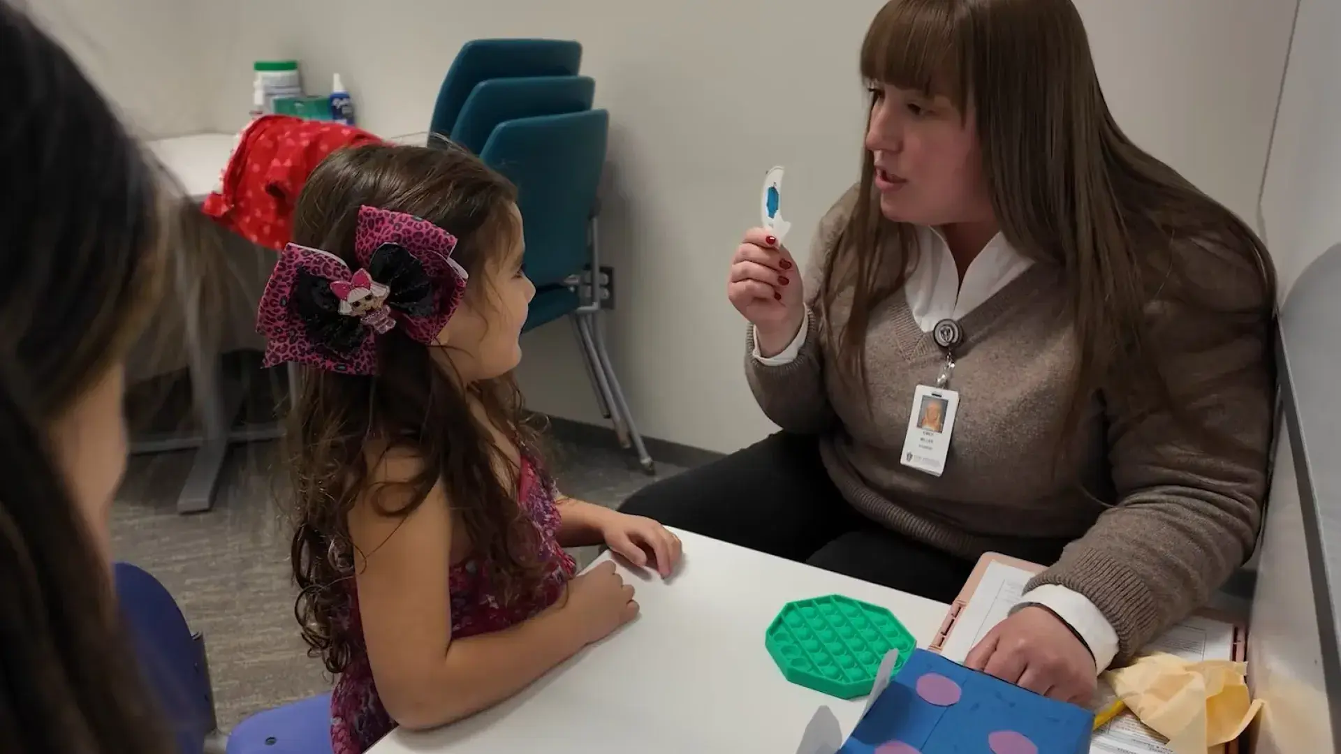 woman holding a card in front of a little girl