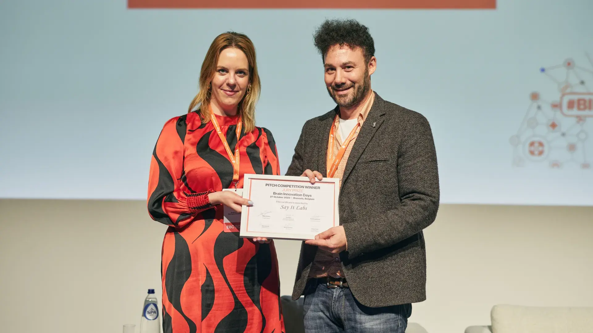 man with award next to woman on left 