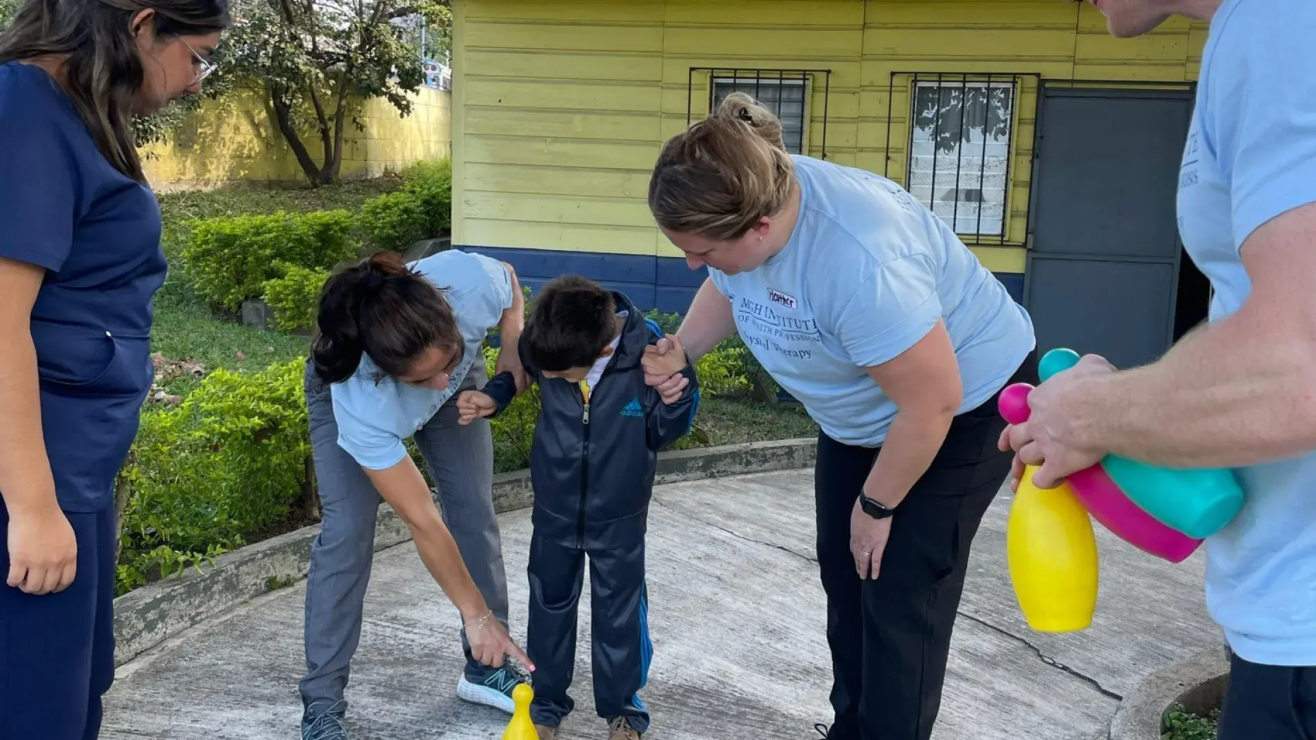three PT students working with Guatemalan patient 