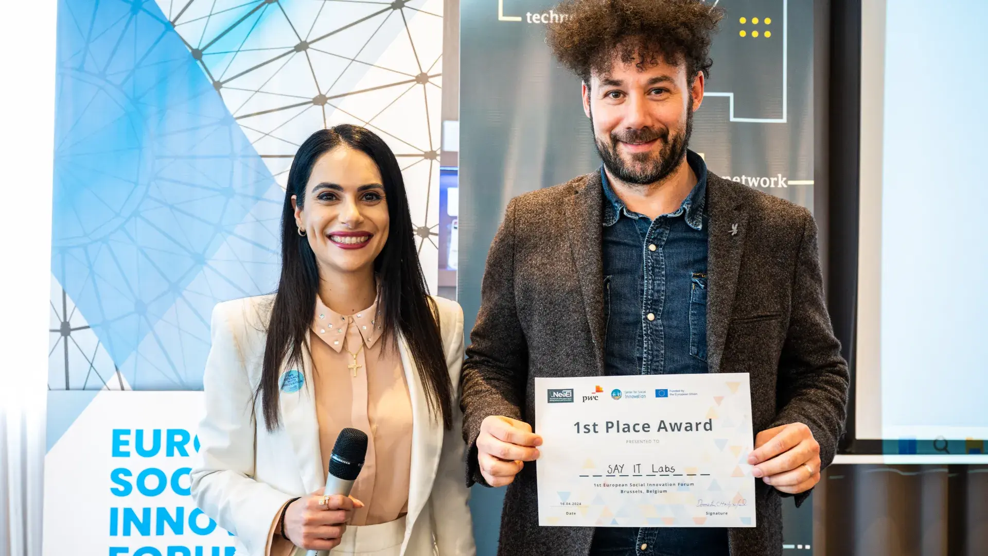 Man with award next to woman 