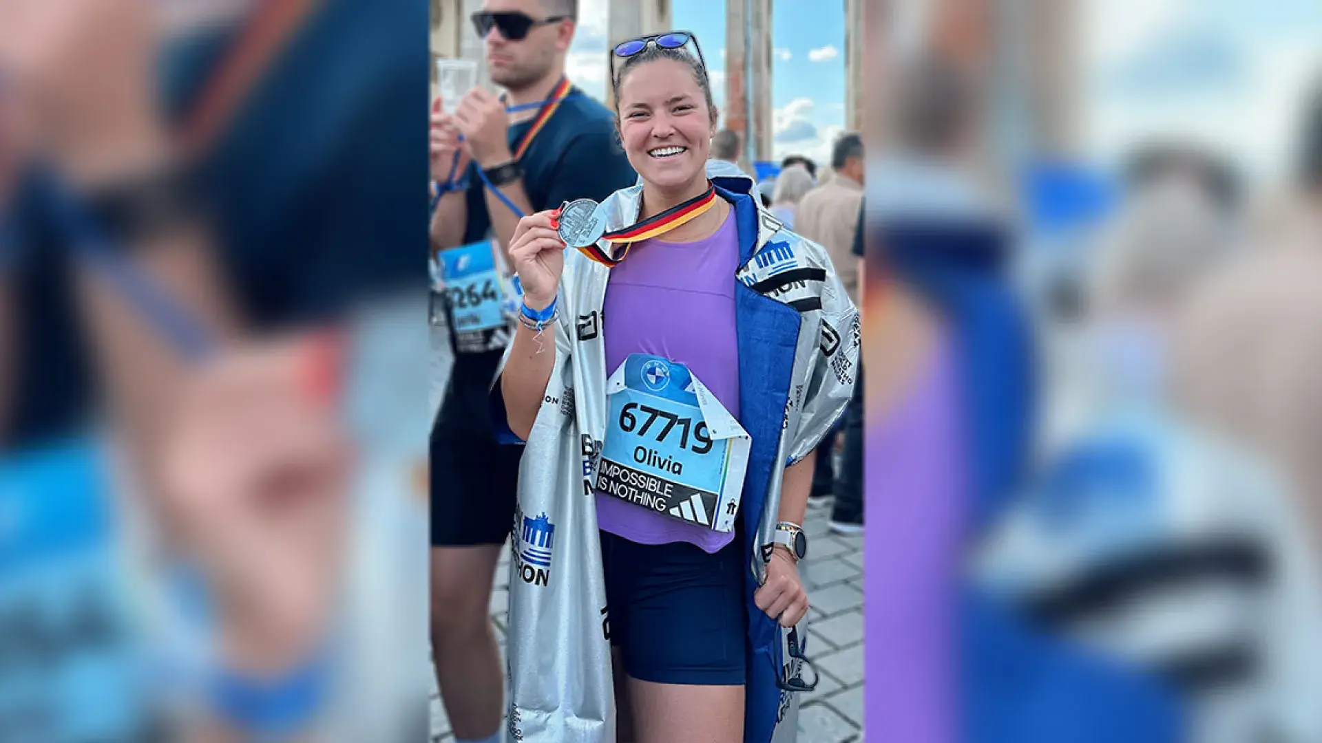 woman holding marathon medal 
