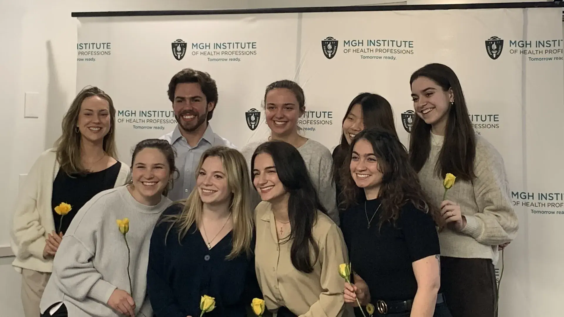 Nice people hold flowers and pose as a group