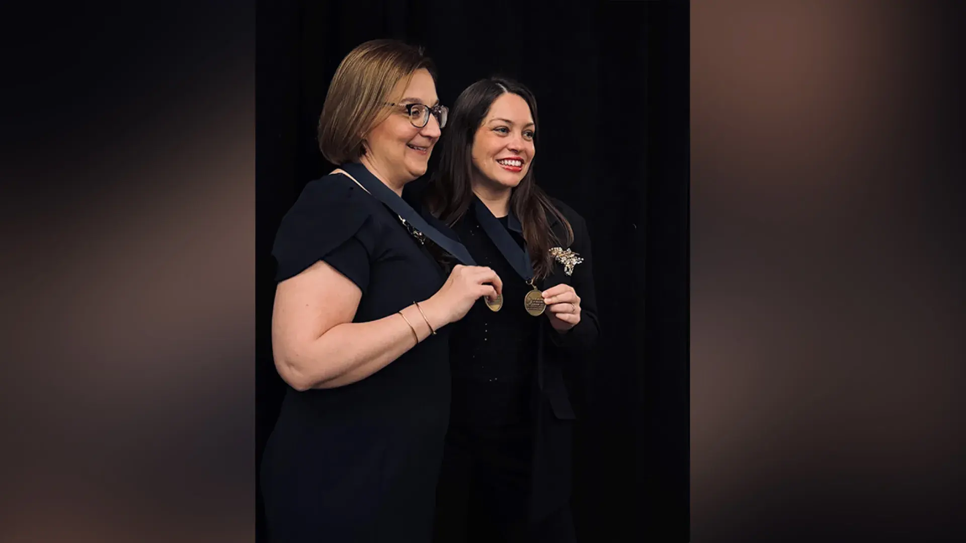 Two women holding medals 