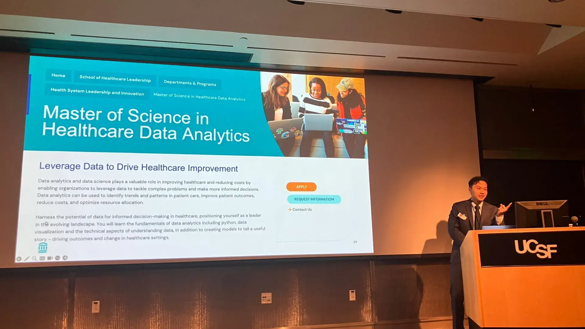 A man stands at a podium with the initials UCSF