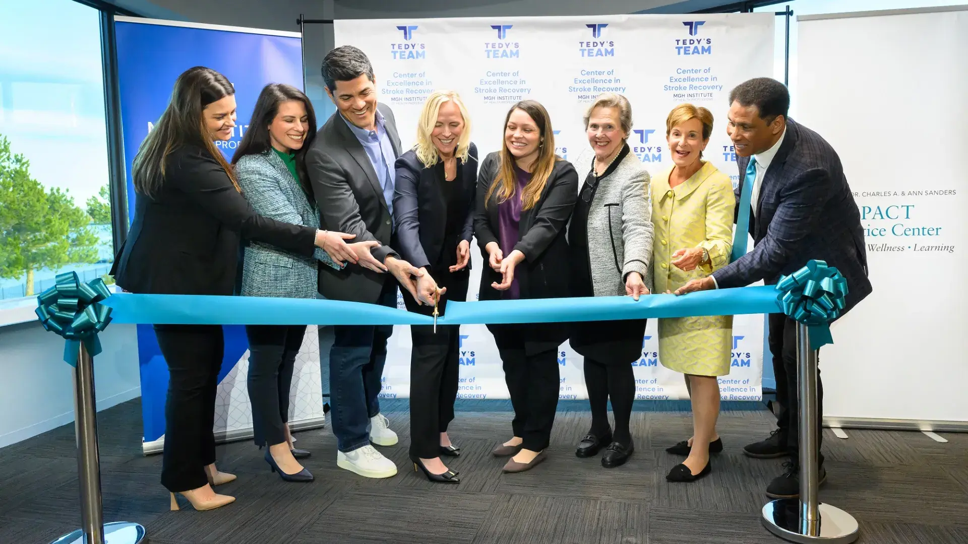 People cutting a ceremonial teal ribbon
