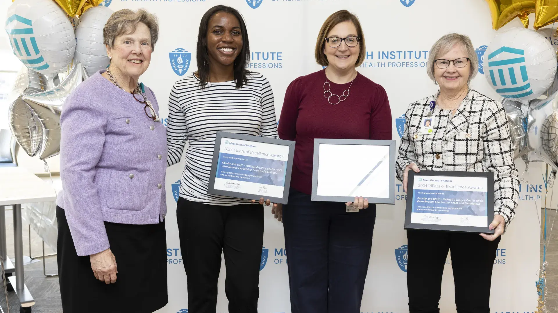 A group of people stand in front of a backdrop holding an award