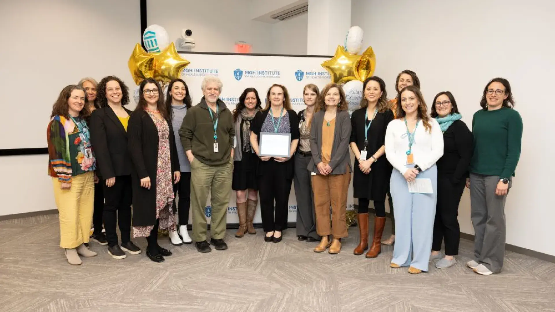 A group of people stand in front of a backdrop holding an award