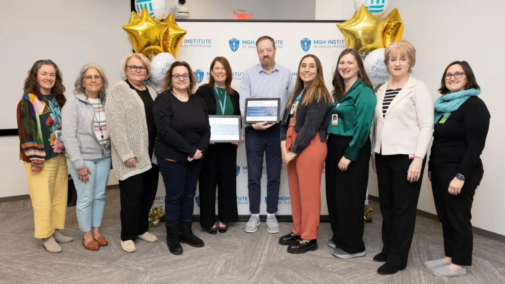 A group of people stand in front of a backdrop holding an award