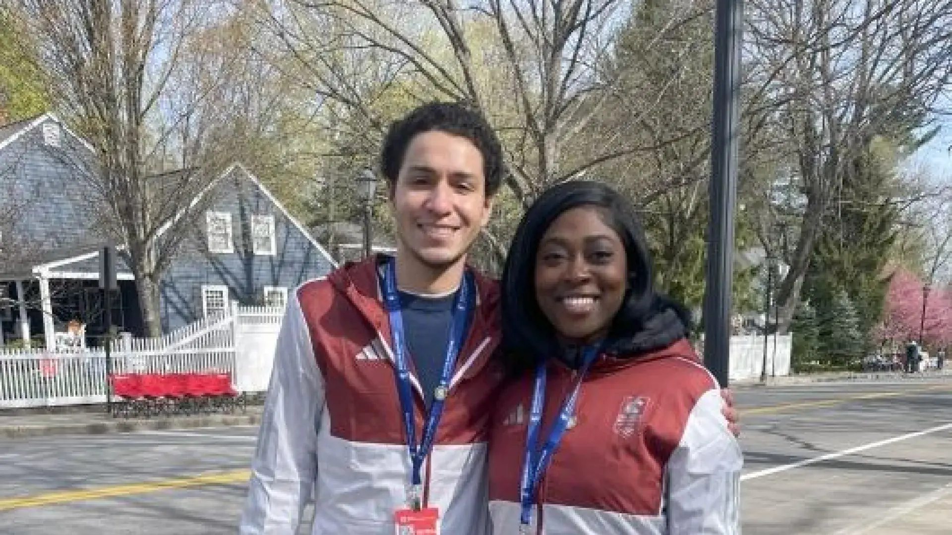 Two people pose together with medical credential around their necks